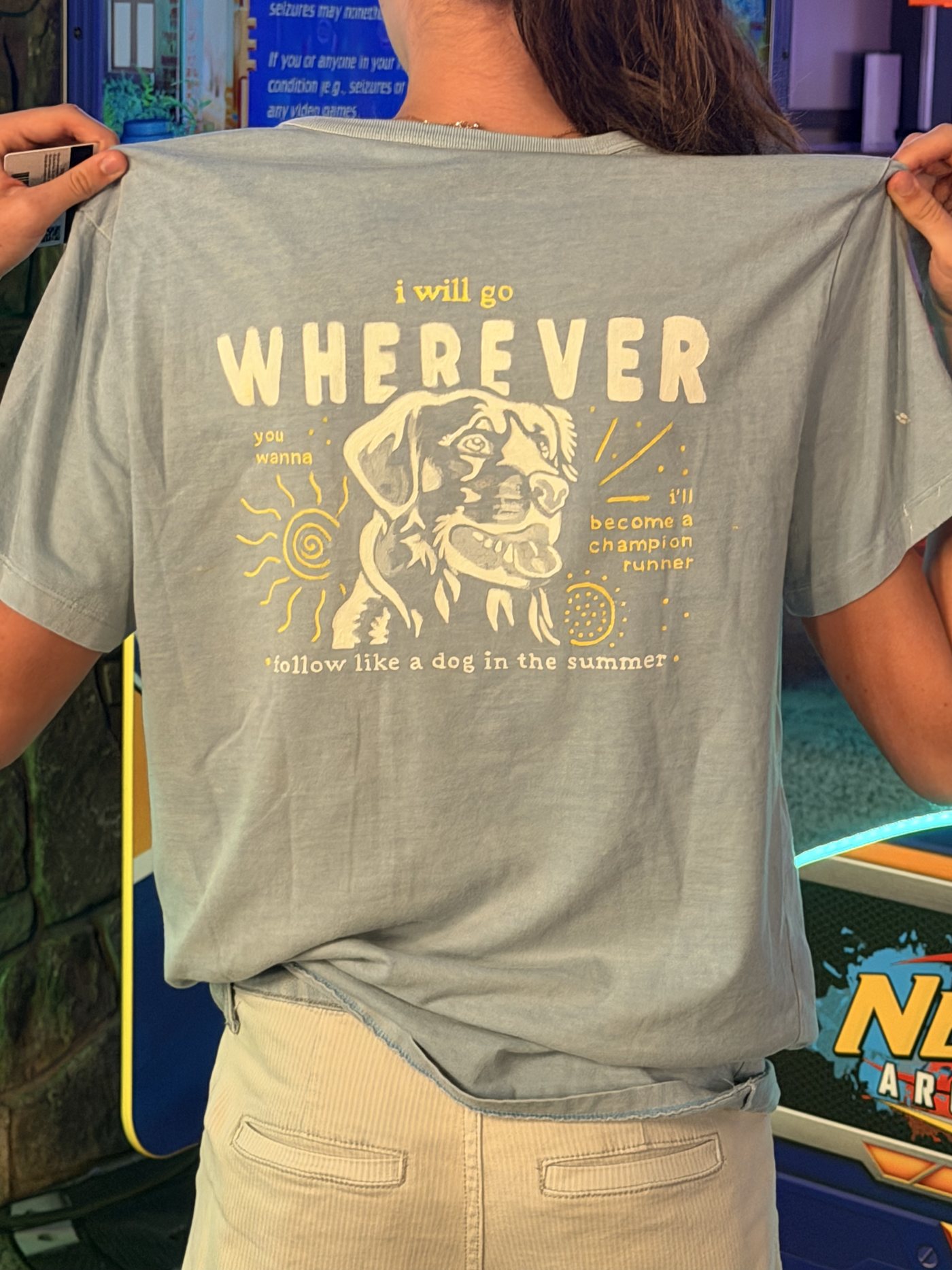 Light blue T-shirt hand-painted with a dog, a sun, and the lyrics I will go wherever