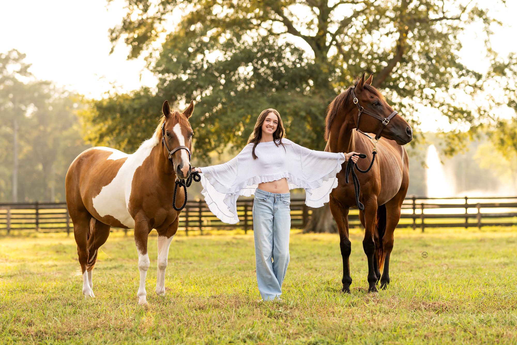 Juliette standing in a green pasture between her two horses